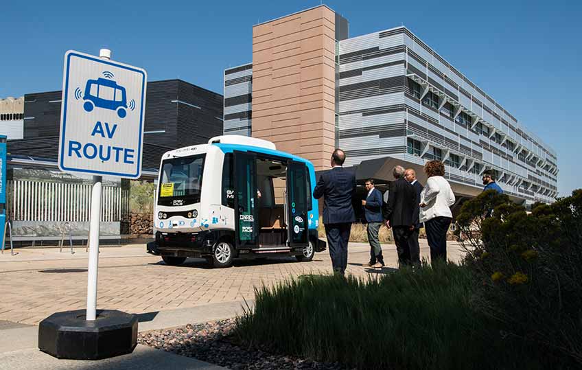 NREL employees line up outside to board the EasyMile automated electric shuttle on the NREL campus.