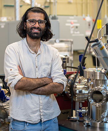 Arnav Deshpande stands inside lab with chemistry equipment