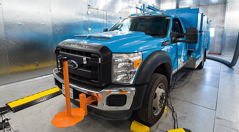 Photo of blue Ford utility vehicle in an environmental chamber, with shiny silver walls, for thermal testing.