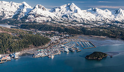 Aerial view of the shoreline of Cordova, Alaska with mountain range in the background