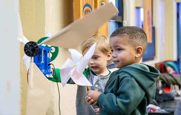 Two children interact with model wind turbines.