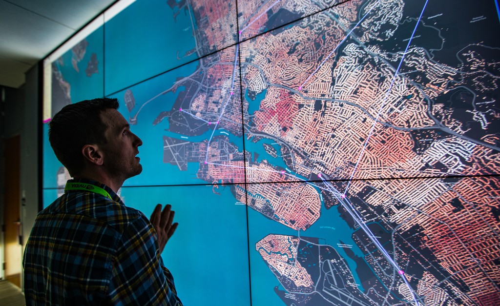 Photo of a person looking at a map on a large display screen