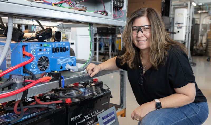 Person bends down to adjust equipment inside lab