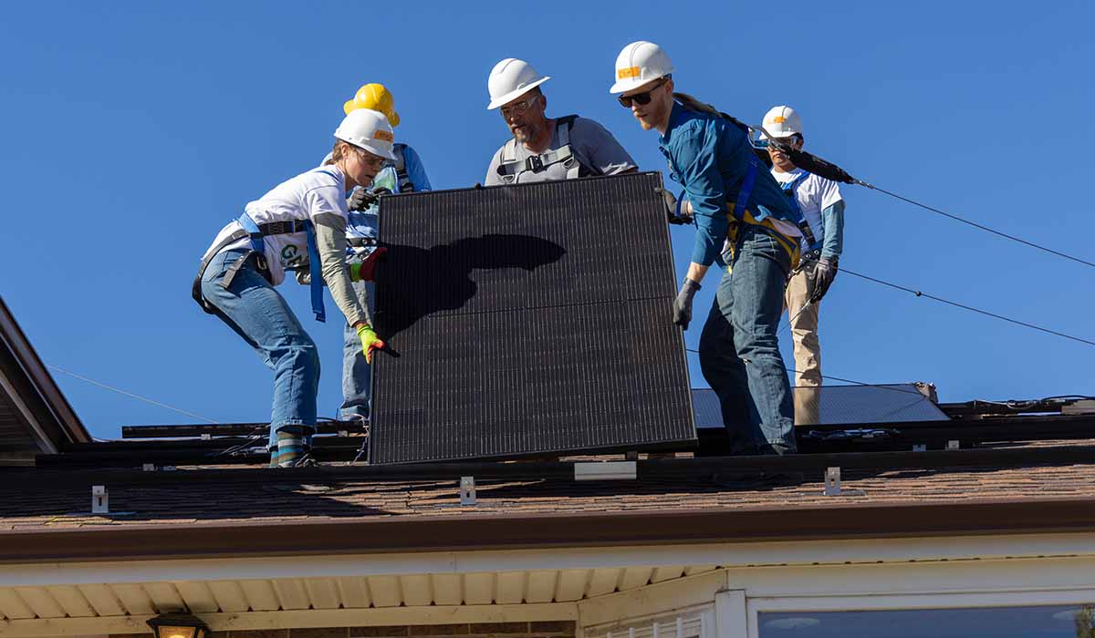 People install solar panels on roof of house.