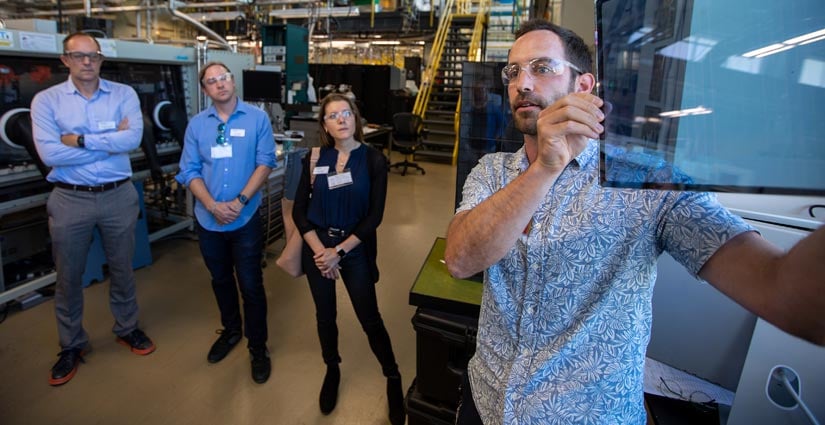 NREL researcher shows energy execs a photovoltaic window.