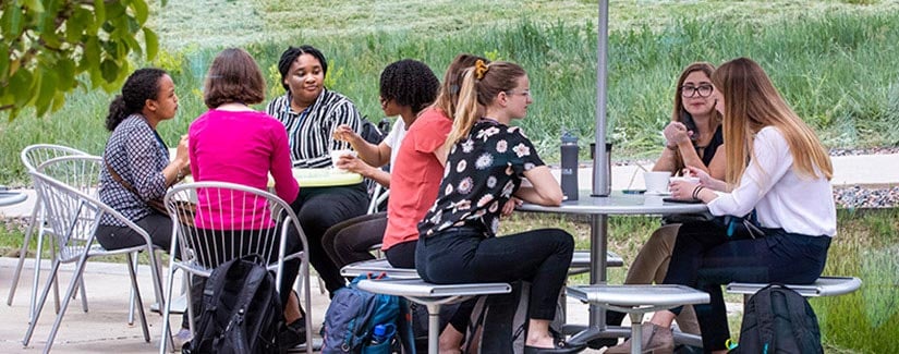 Staff relaxes at outdoor tables.