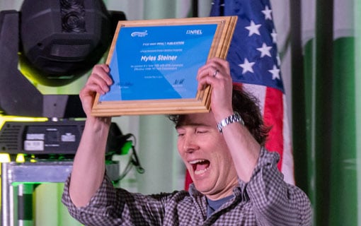 A person lifting a plaque above their head.