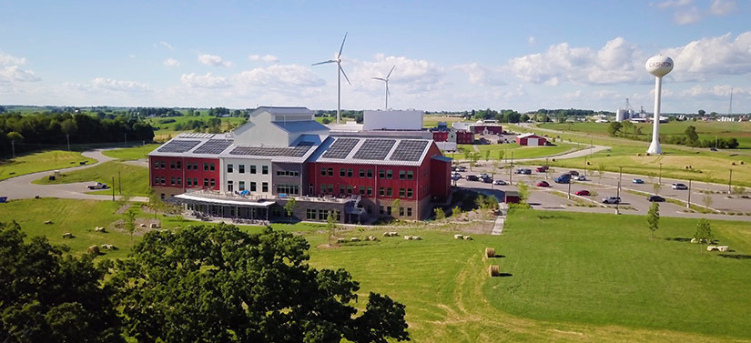 dwfs-hero Photo of a building in a rural setting. The building has solar panels and medium-size wind turbines in the background.