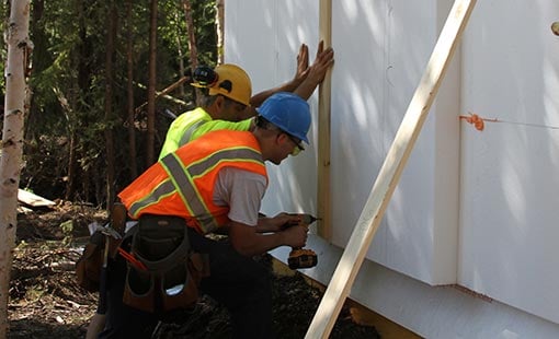 Two men using power tools.