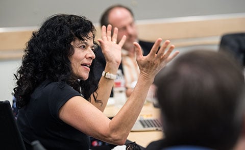 Person talking with hands at meeting table.