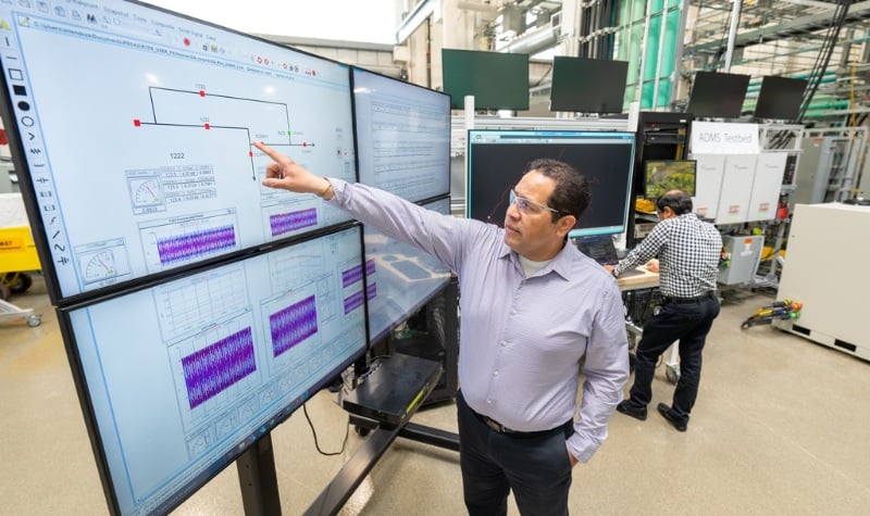 Person pointing at screen displaying data