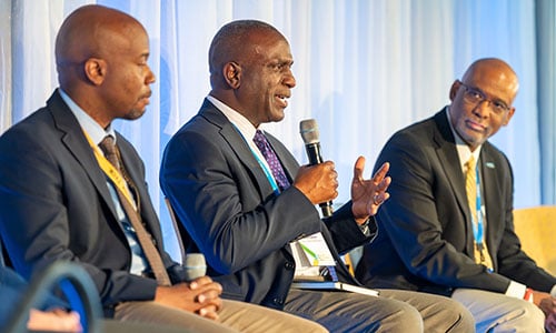 alt="Three people on stage during panel discussion."