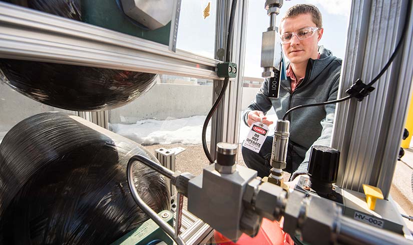 Photo of a researcher working on mechanical equipment at the Energy Systems Integration Facility.