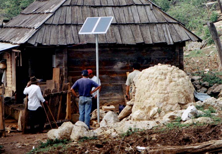 power-africa13563 A small ground-mounted PV panel outside a small hut.