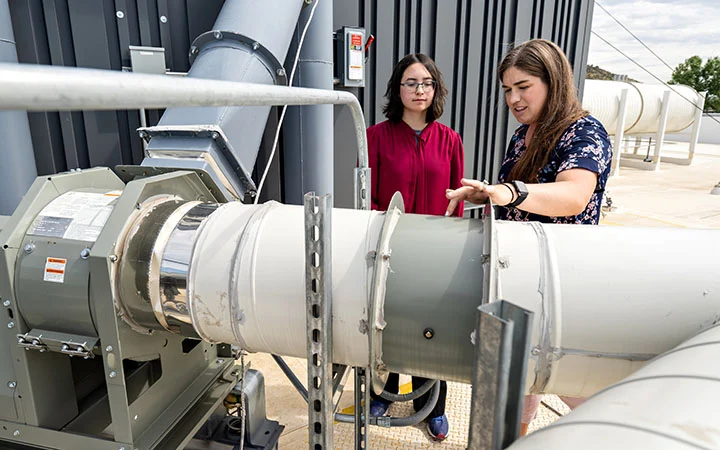 A mentor and an intern looking at equipment.