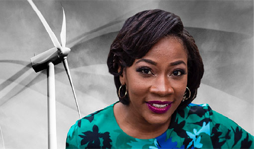 Angel McCoy in front of wind turbine blades