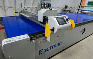 360tour-12-5248 An arm controlled by a touch screen slides across a large blue sheet of fabric.