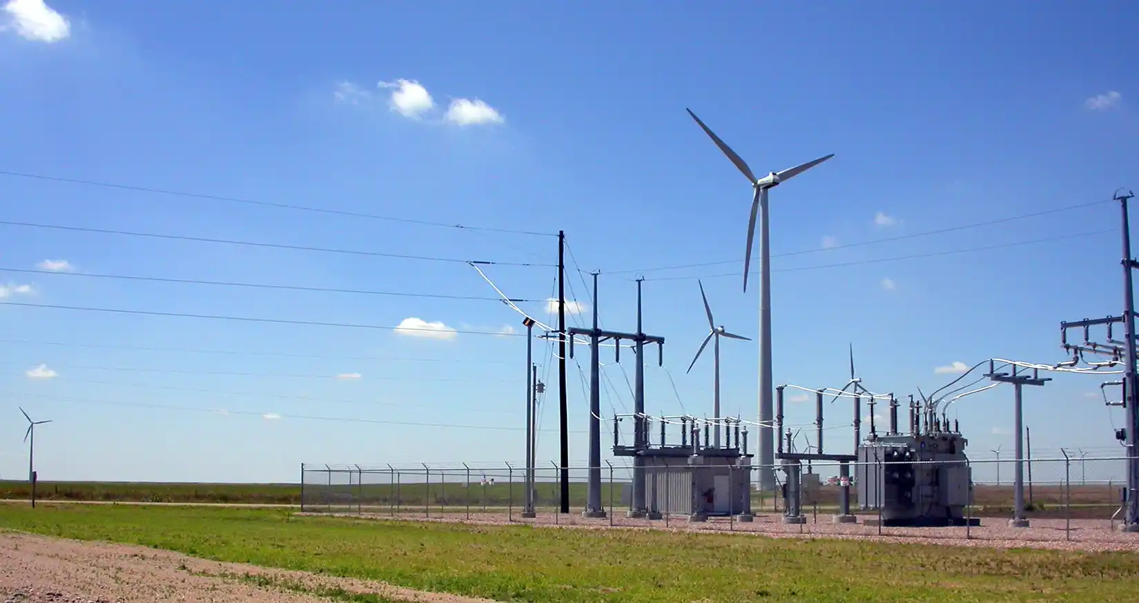 grid-systems-integration-14108 Electrical grid system next to wind turbines.