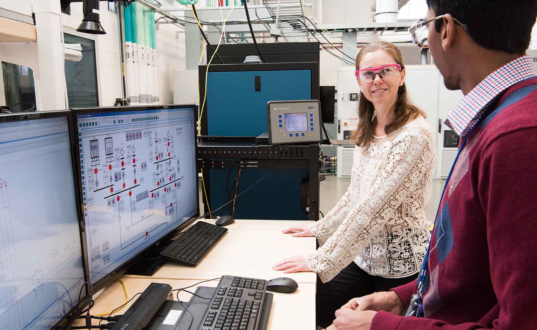 NREL engineers Kumar Prabhakar and Annabelle Pratt, run a grid simulation, using industrial scale inverters for a Borrego Springs Project.