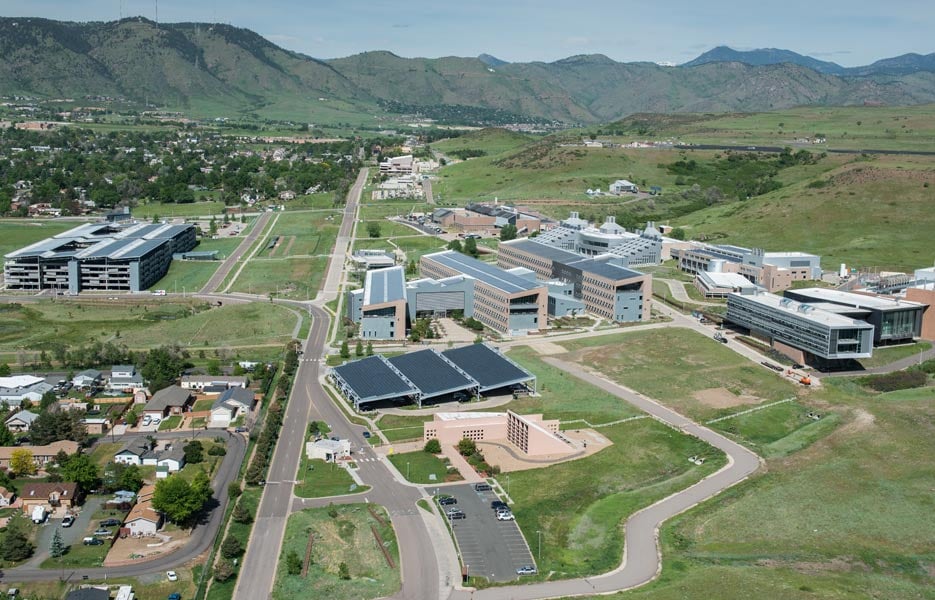 Aerial view of a campus with buildings set against the mountains.