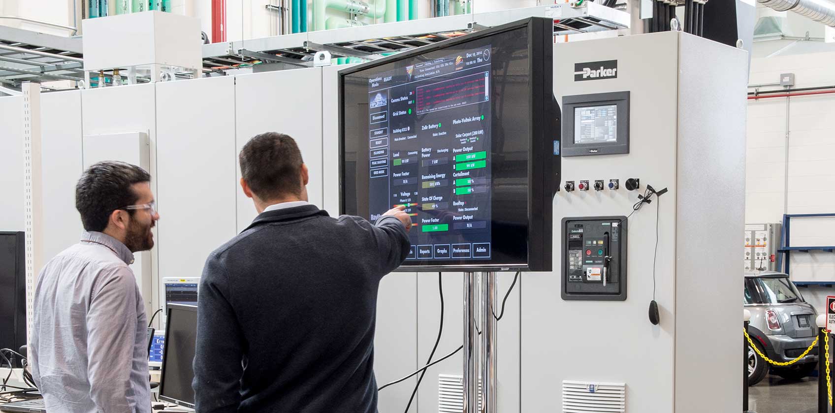 Two scientists pointing at a computer screen in a laboratory.