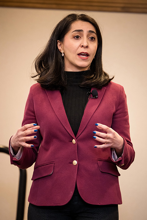 A woman in a suit stands talking.
