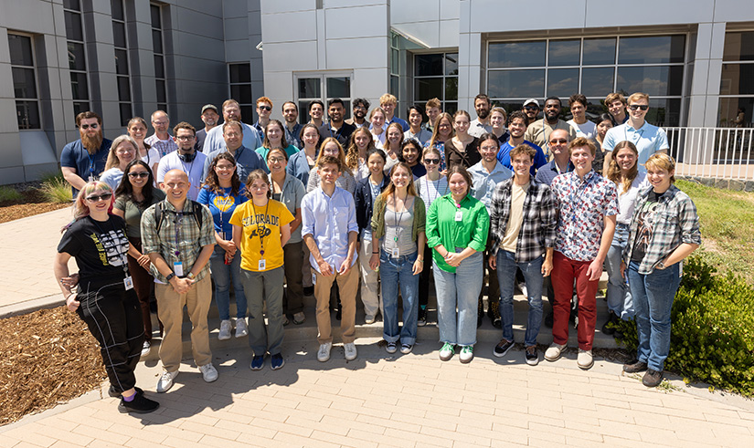 A large group of interns standing outside in front of a building. 