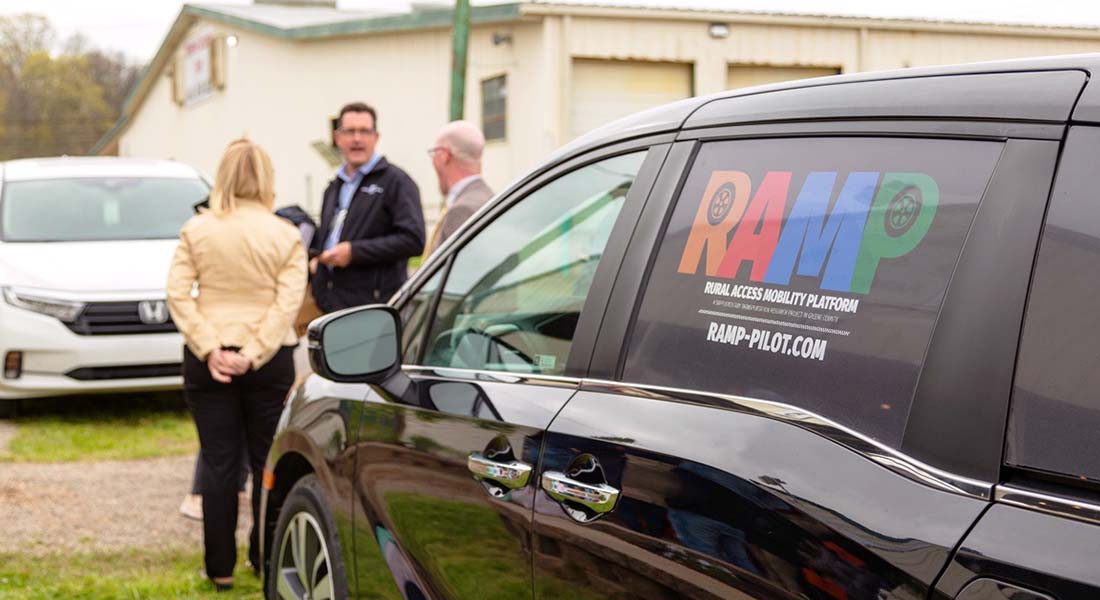 A group of people standing infront of a van.