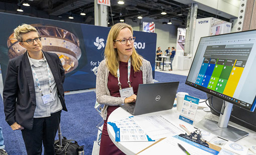 Two people looking at data on a computer screen at a tradeshow