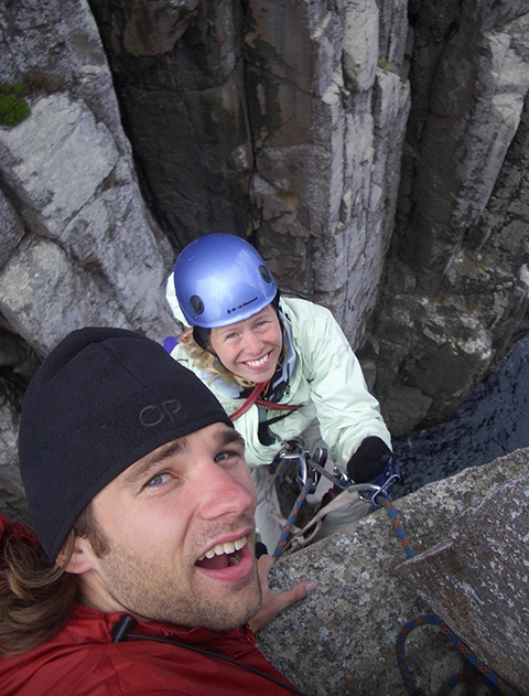 Two people wearing rock climbing gear and helmets.