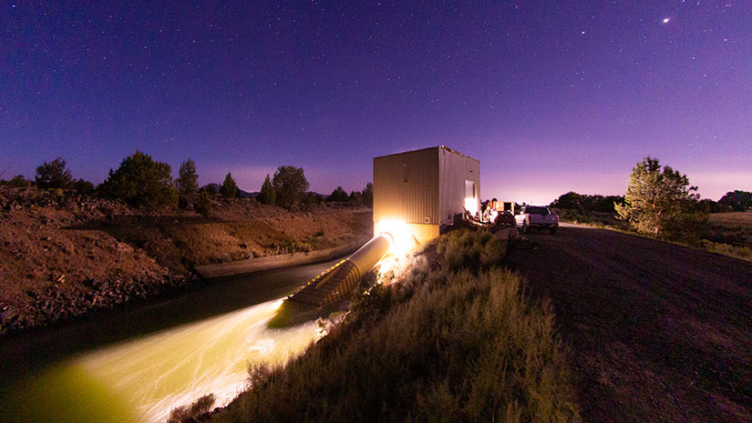 A hydropower plant lit up at night