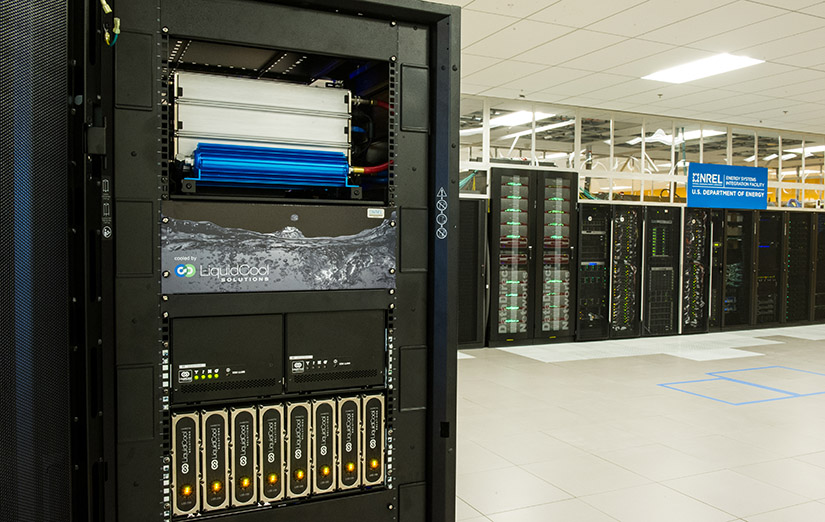 A computer demolition sits in a computer shack with more servers in the background. 