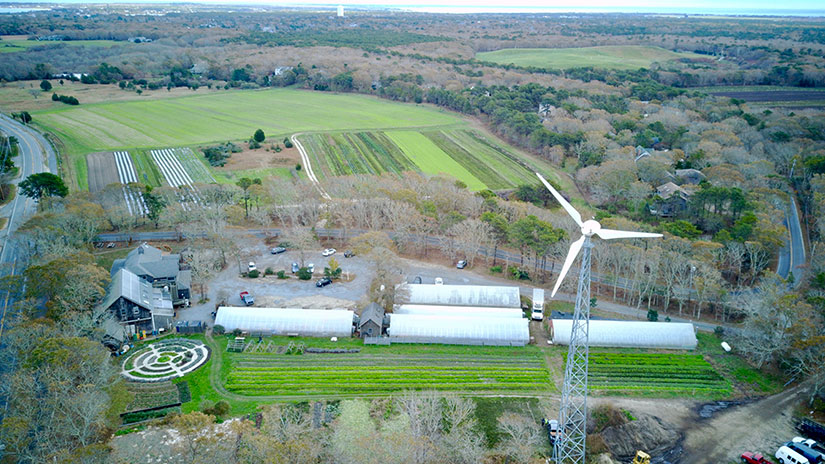 Aerial view of a small wind turbine next to a farm
