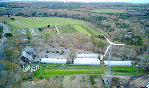 Aerial view of a small wind turbine next to a farm