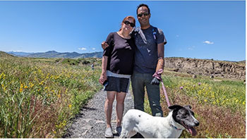 Jibo standing on a trail with his wife and dog