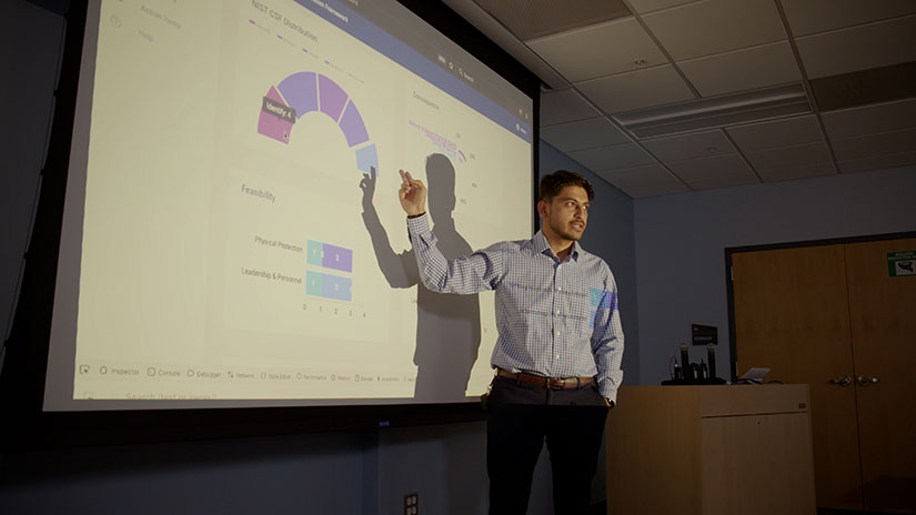 Anuj Sanghvi presenting in front of a projector screen