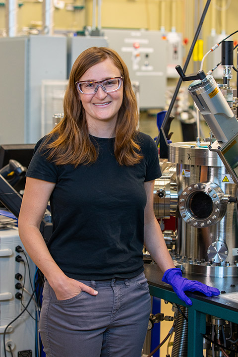 A person wearing safety glasses smiling in a laboratory.