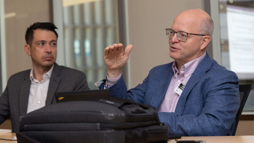 Two people talking at a panel discussion table