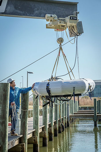 Person preparing device on dock for deployment