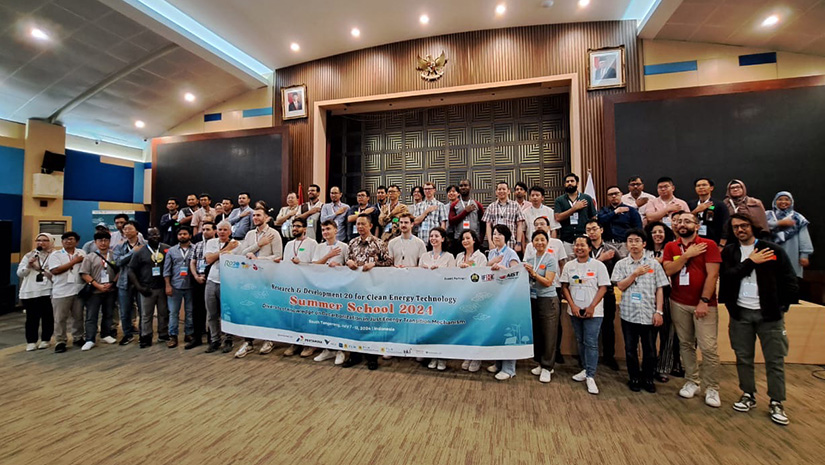 A group of people in a room holding a banner.