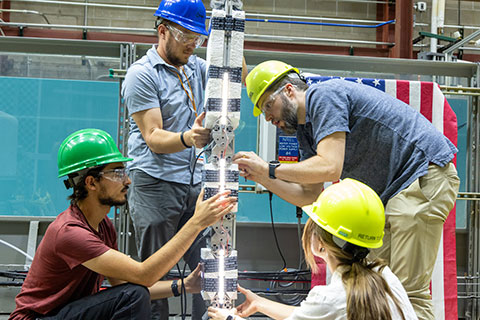 Boren, Musgrave, Hess and Chamot work on an origami flexWEC