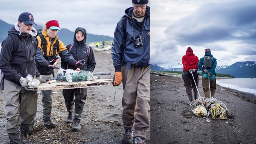 Knauer, on a beach and in rain gear, walking behind three other people carrying plastic waste