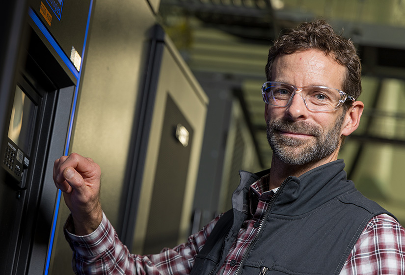 Man stands in the hallway of a research building at NREL.