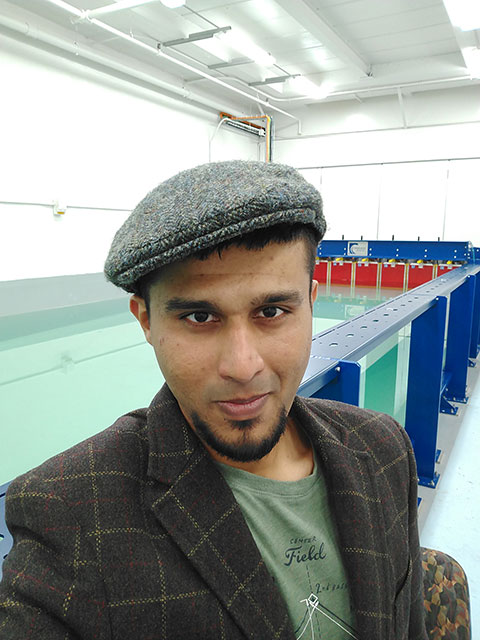 Salman Husain in front of a wave testing tank at Michigan Technological University