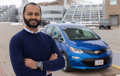 Ranjit Desai, EVSE soft cost project principal investigator, stands in front of an electric vehicle parked at the National Renewable Energy Laboratory’s campus in Golden, Colorado.