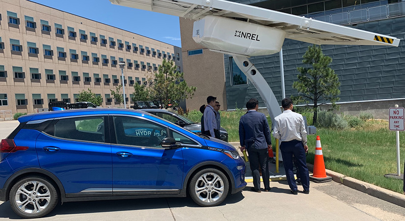 A small group of people standing near a car at NREL.