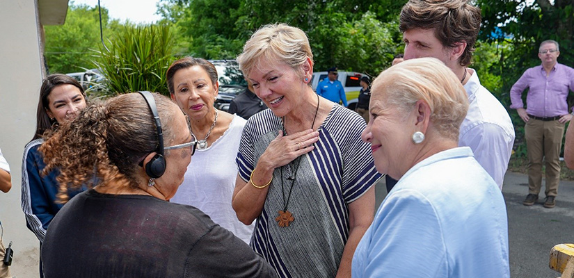 Secretary of Energy Jennifer Granholm and the Mayor of Loíza, Julia Nazario Fuentes, cheerfully talk with a Puerto Rican homeowner.