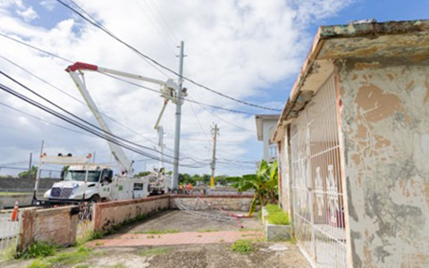 A utility truck with electricians working on powerlines in Puerto Rico.