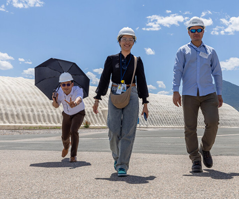 Three people walking outside.