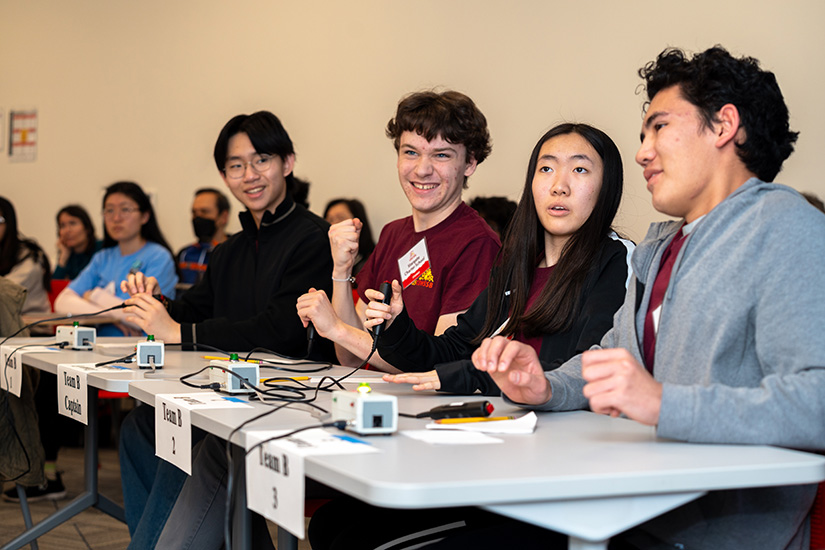 A row of students sitting at a table.